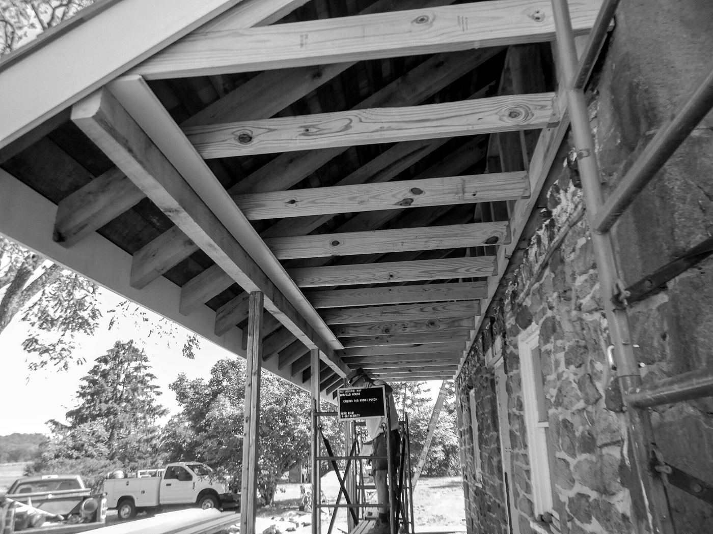 Exposed rafters and framing on a porch roof under construction
